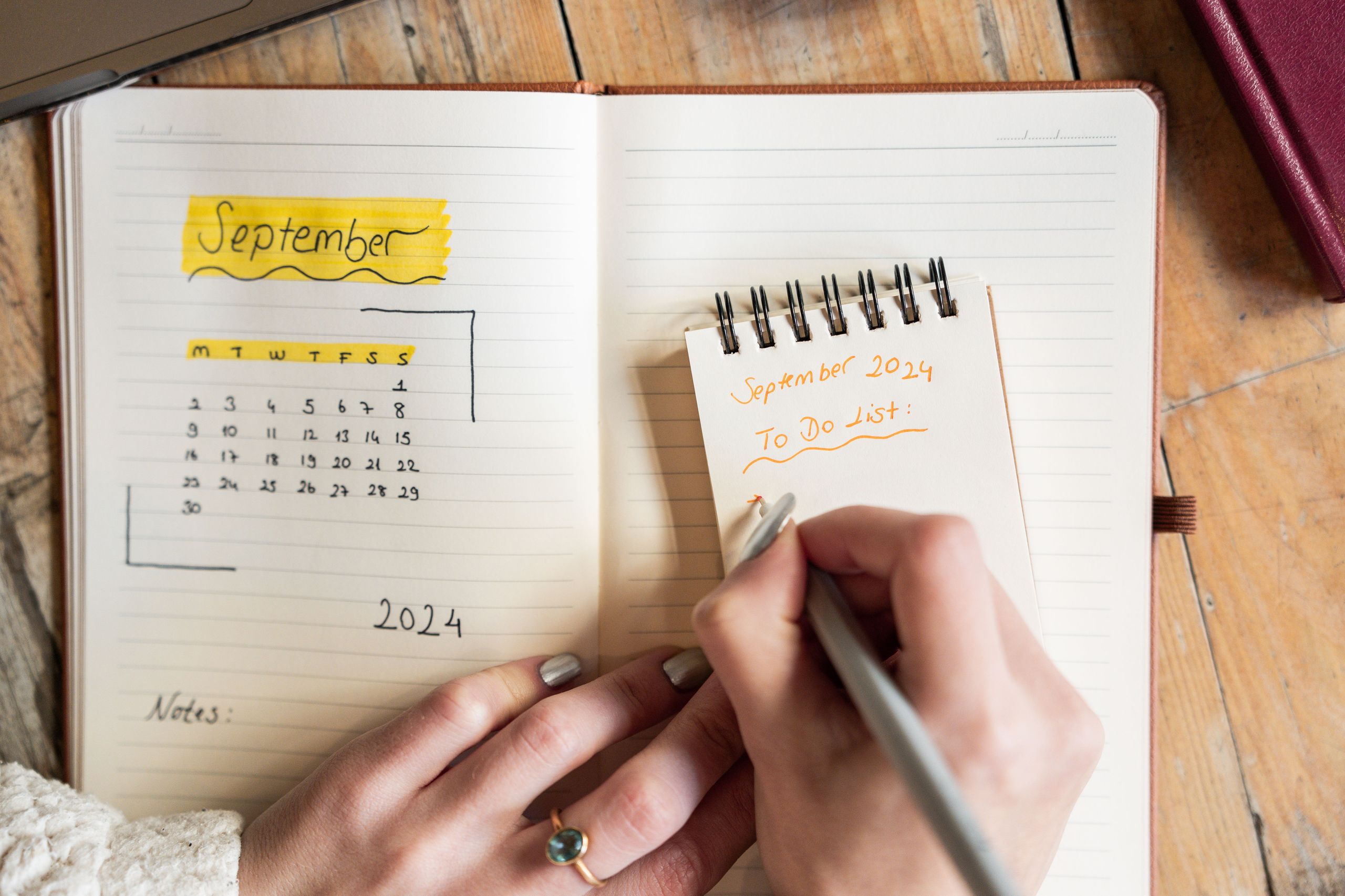 Woman planning her wedding and budget in a notebook at a bright desk